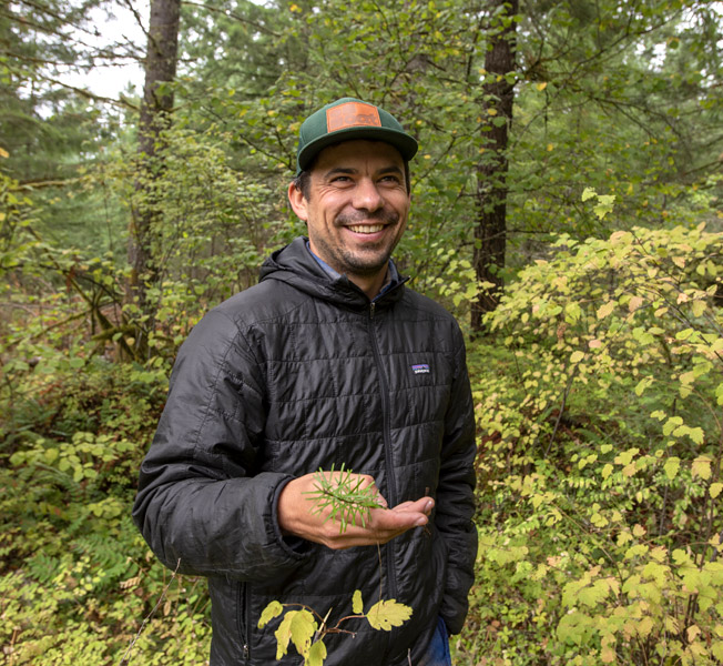 Ben in woods holding seedling