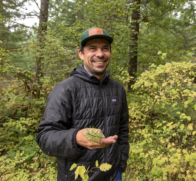 Ben in woods holding seedling
