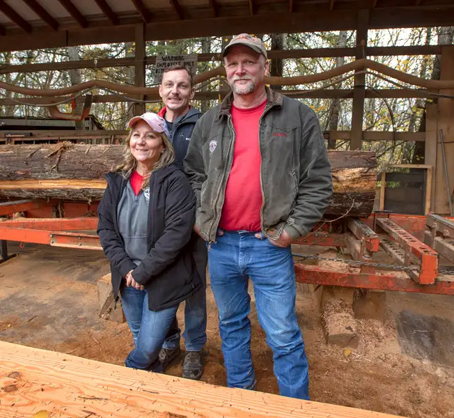 Kastor family in front of logging equipment