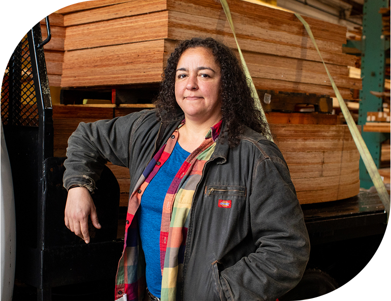 Vendor standing next to stack of wood