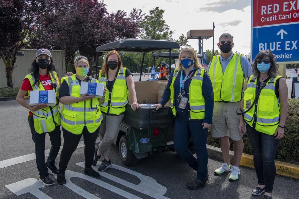 Six staff members from the Red Cross, OHSU, and Port of Portland stand and pose for a photo at the Red Lot vaccine clinic.