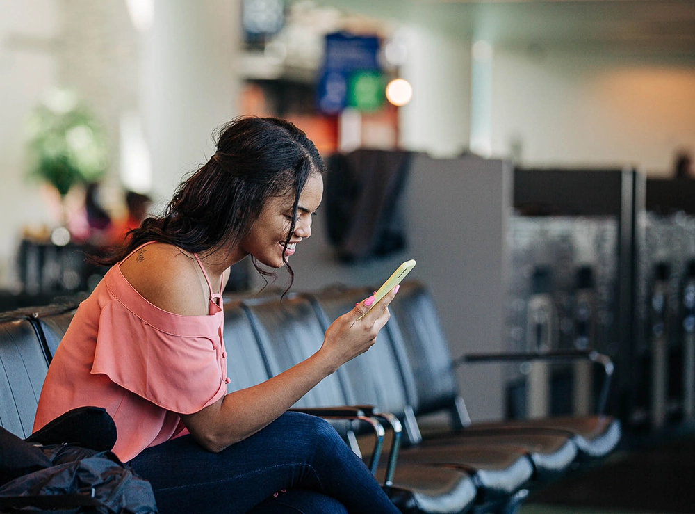 a young woman smiles looking at her phone