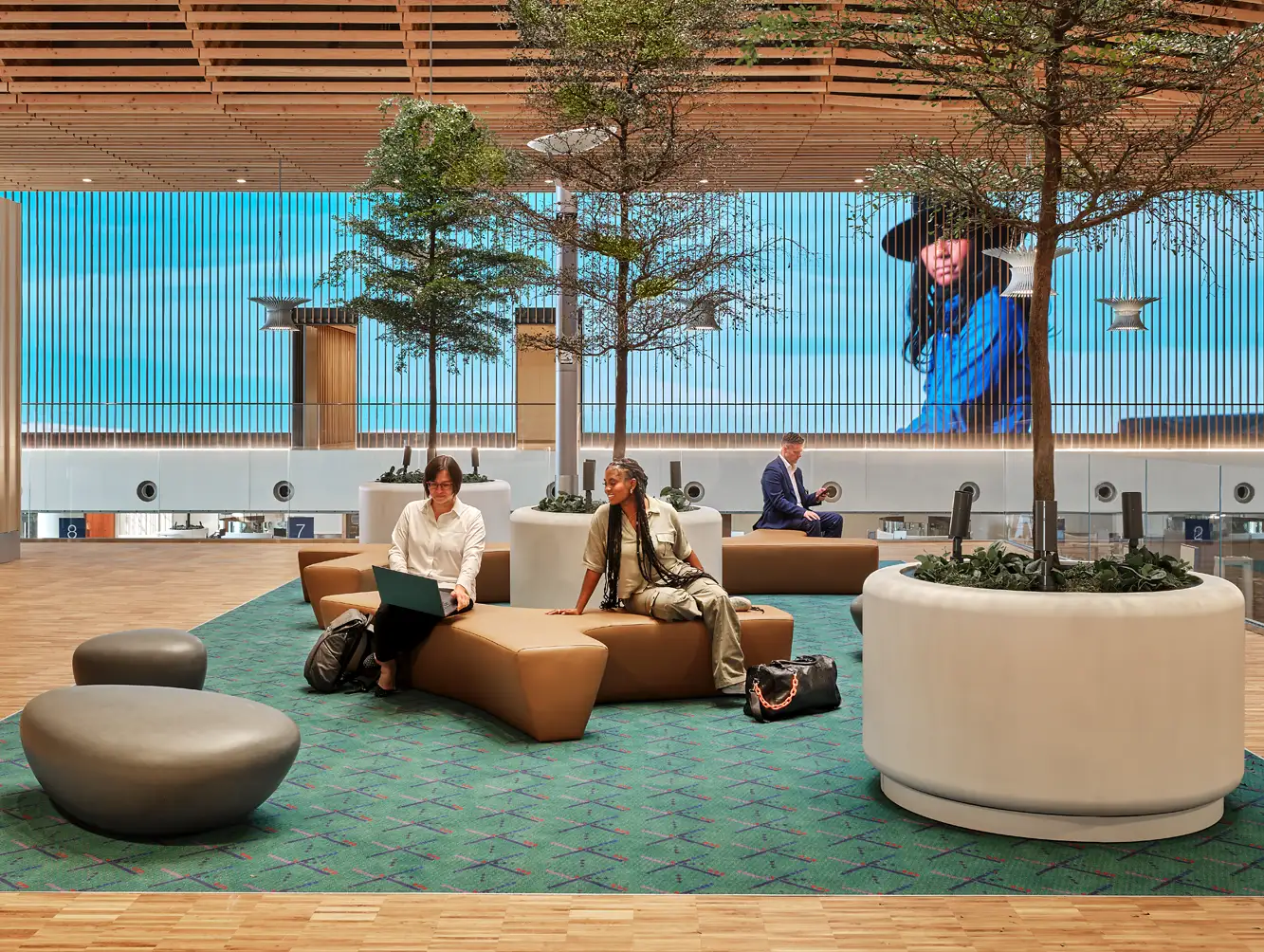 Travelers sitting in front of video walls at PDX