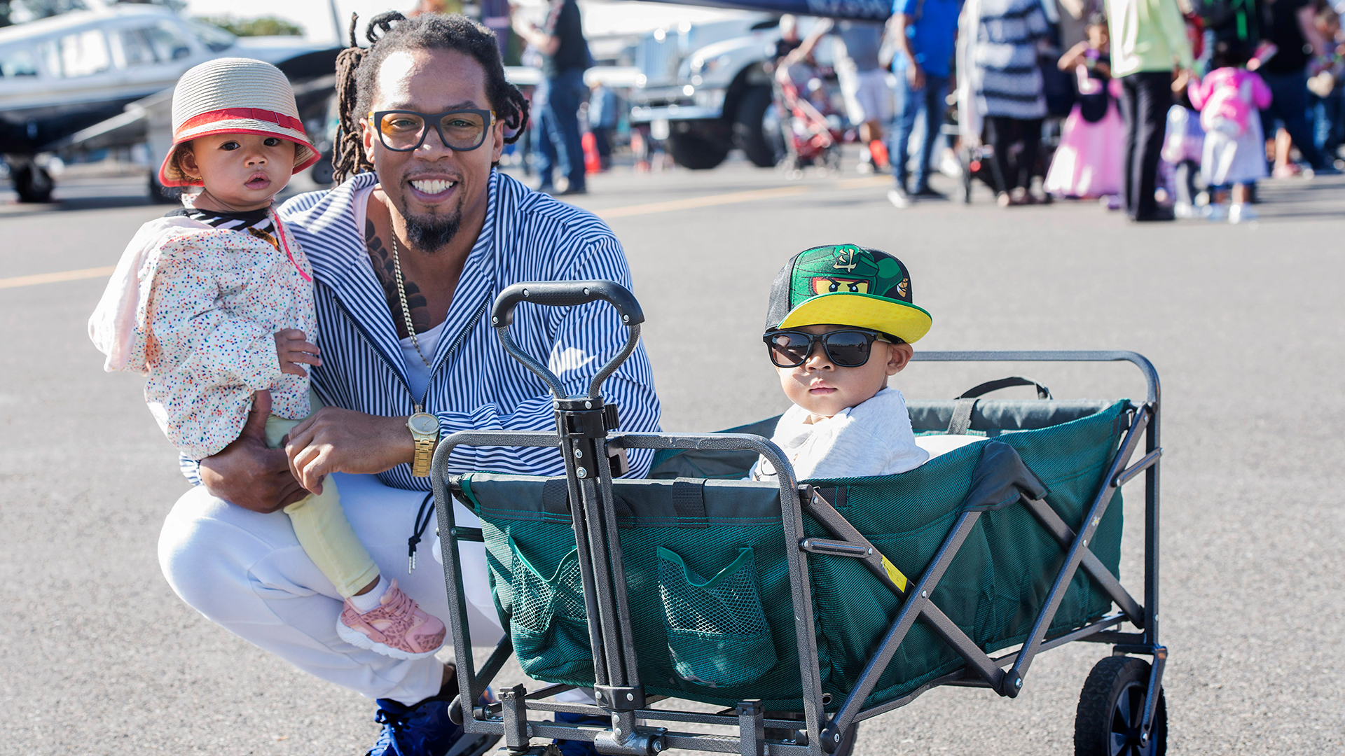 Black family with one child held and another in wagon