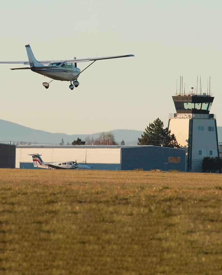 Small plane landing with air traffic control in background