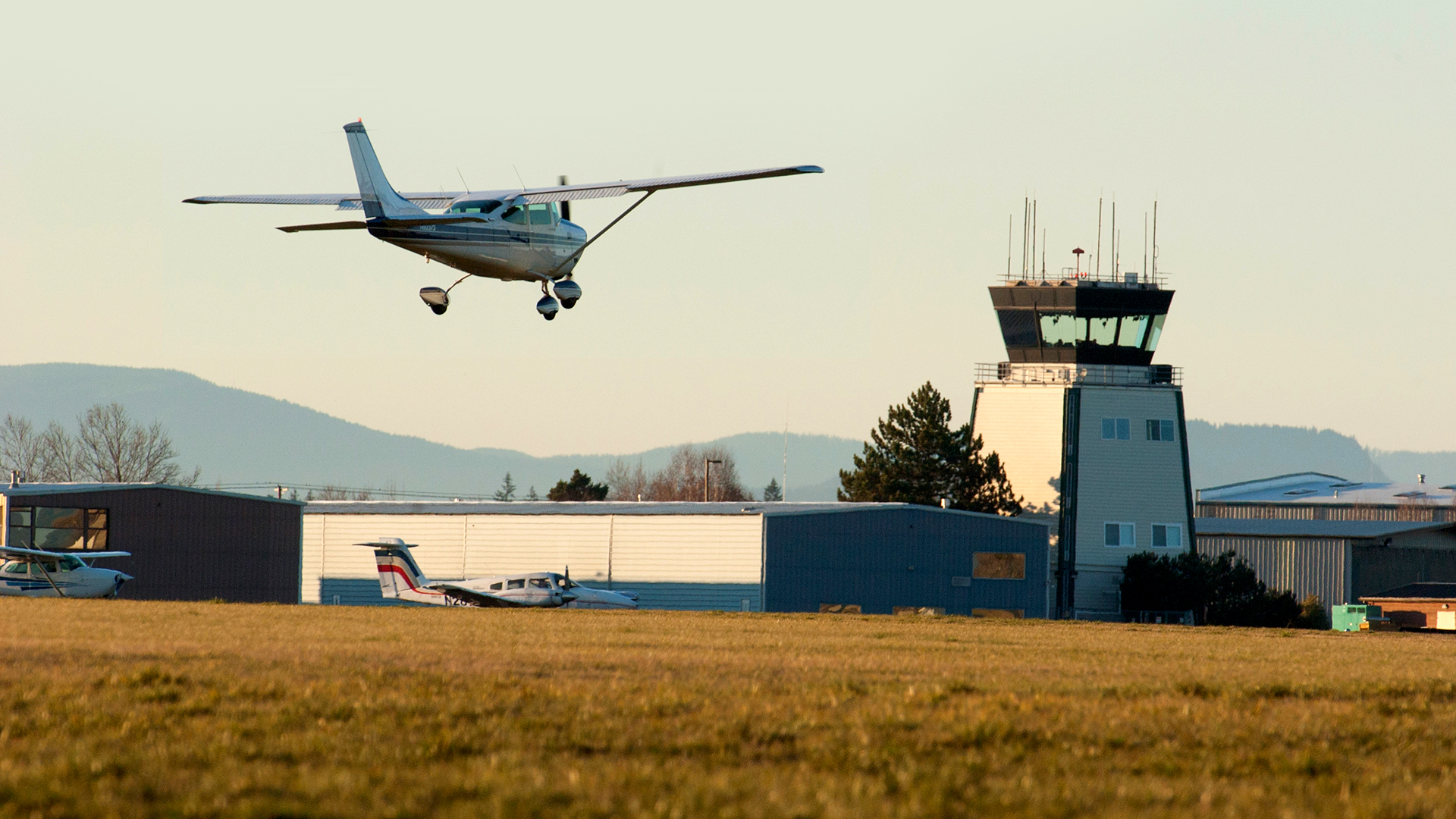 Small plane landing with air traffic control in background