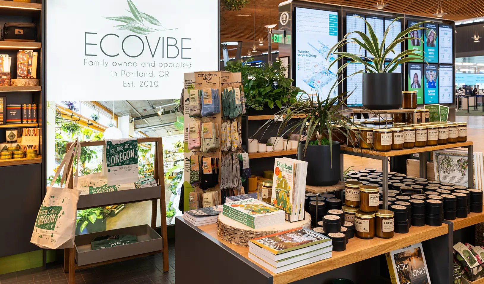 Interior of Ecovibe and illuminated sign looking out at the flight information display in the ticket hall