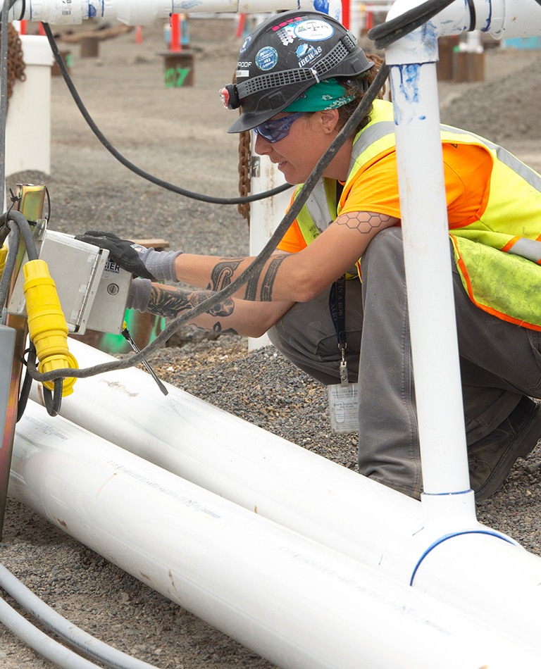 women working on electrical box