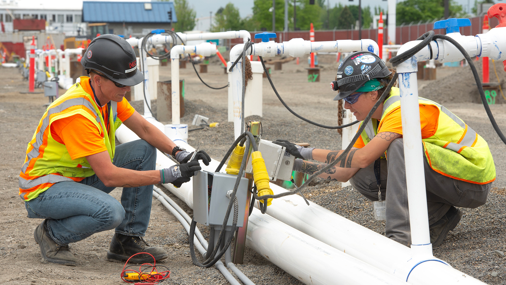 women working on electrical box