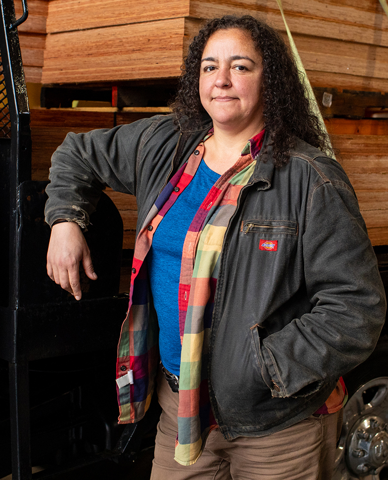 woman standing in front of truck with wood
