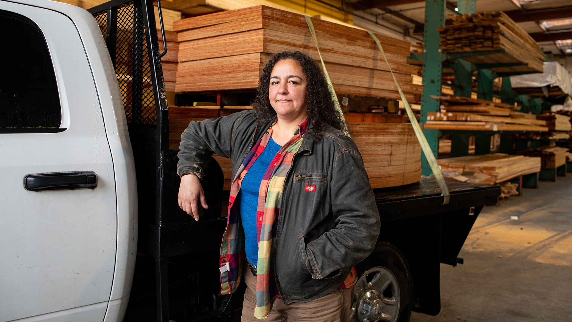 woman standing in front of truck with wood