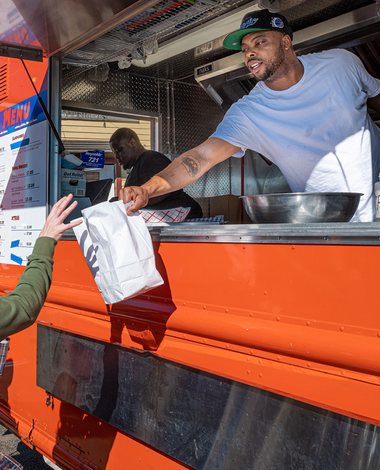 Men handing out food from food truck