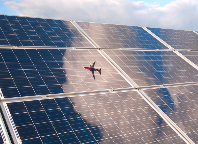 an airplane shines in the reflection of solar panels
