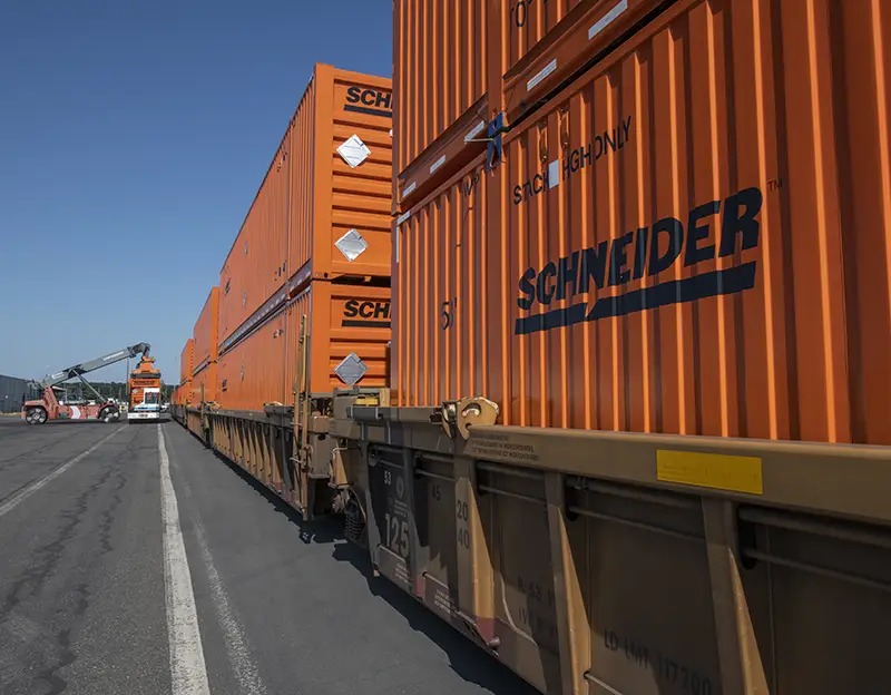 A man in a safety vest and hardhat holds a rope attached to a transformer being unloaded from a vessel at Terminal 6