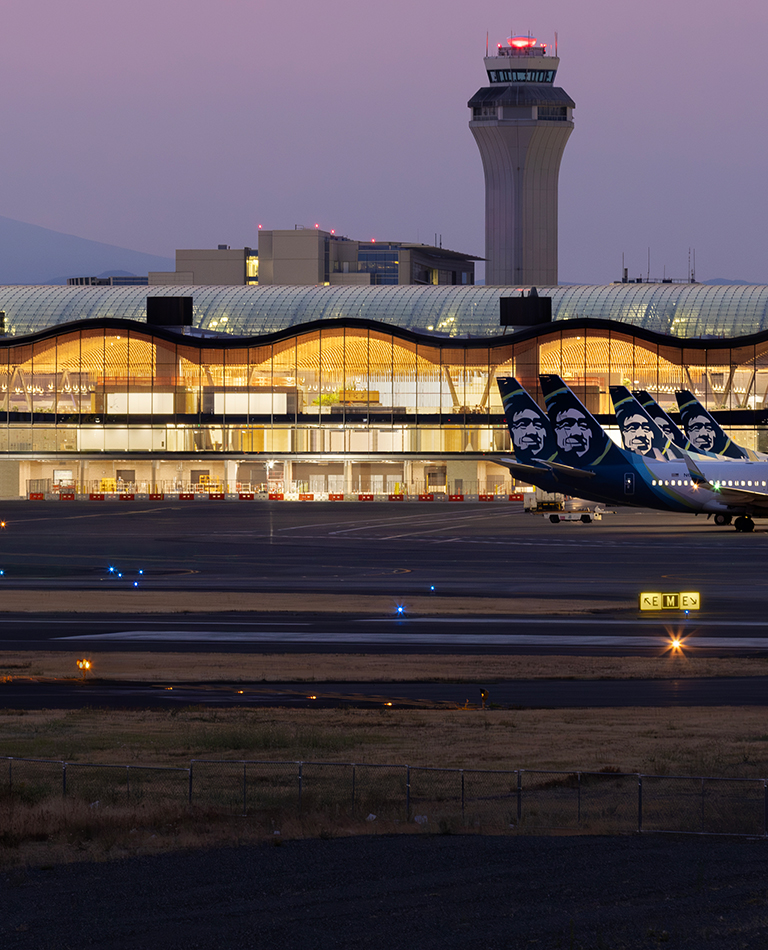 exterior of recently remodeled main terminal with various planes parked at gates