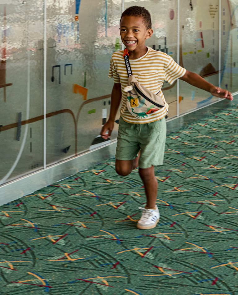 young man running down the concourse connector with family behind