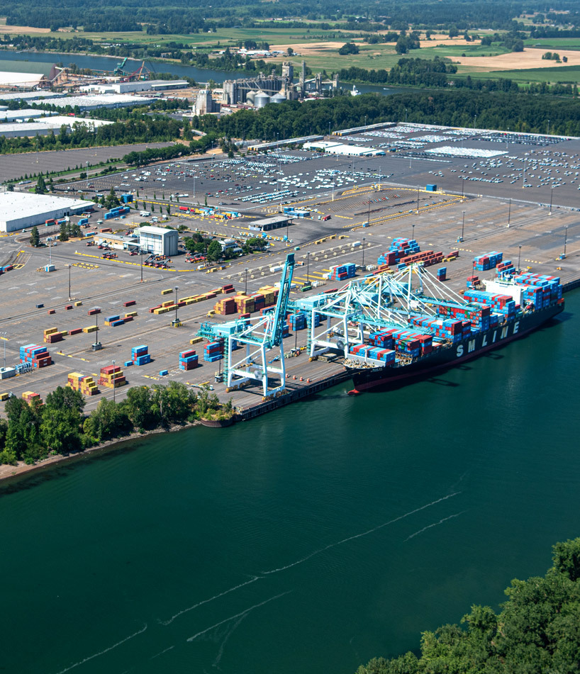 colorful containers at Terminal 6 being unloaded from a vessel by large blue cranes