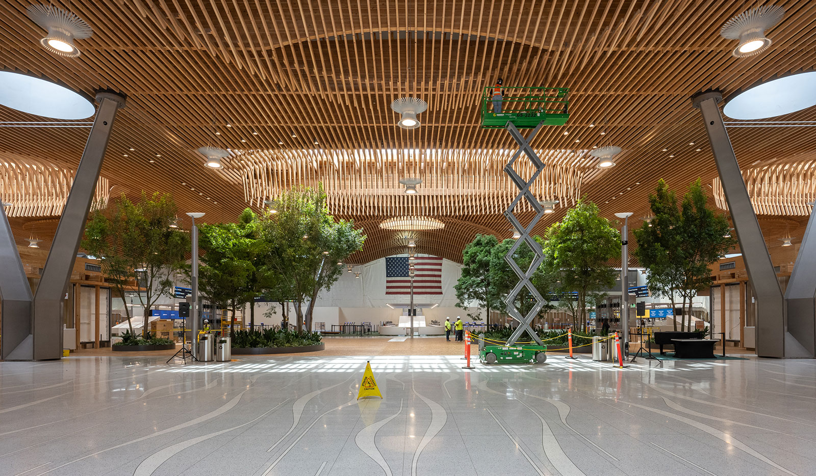 la nueva terminal principal con pisos de terrazo y un elevador de tijera hasta el techo de rejilla de madera