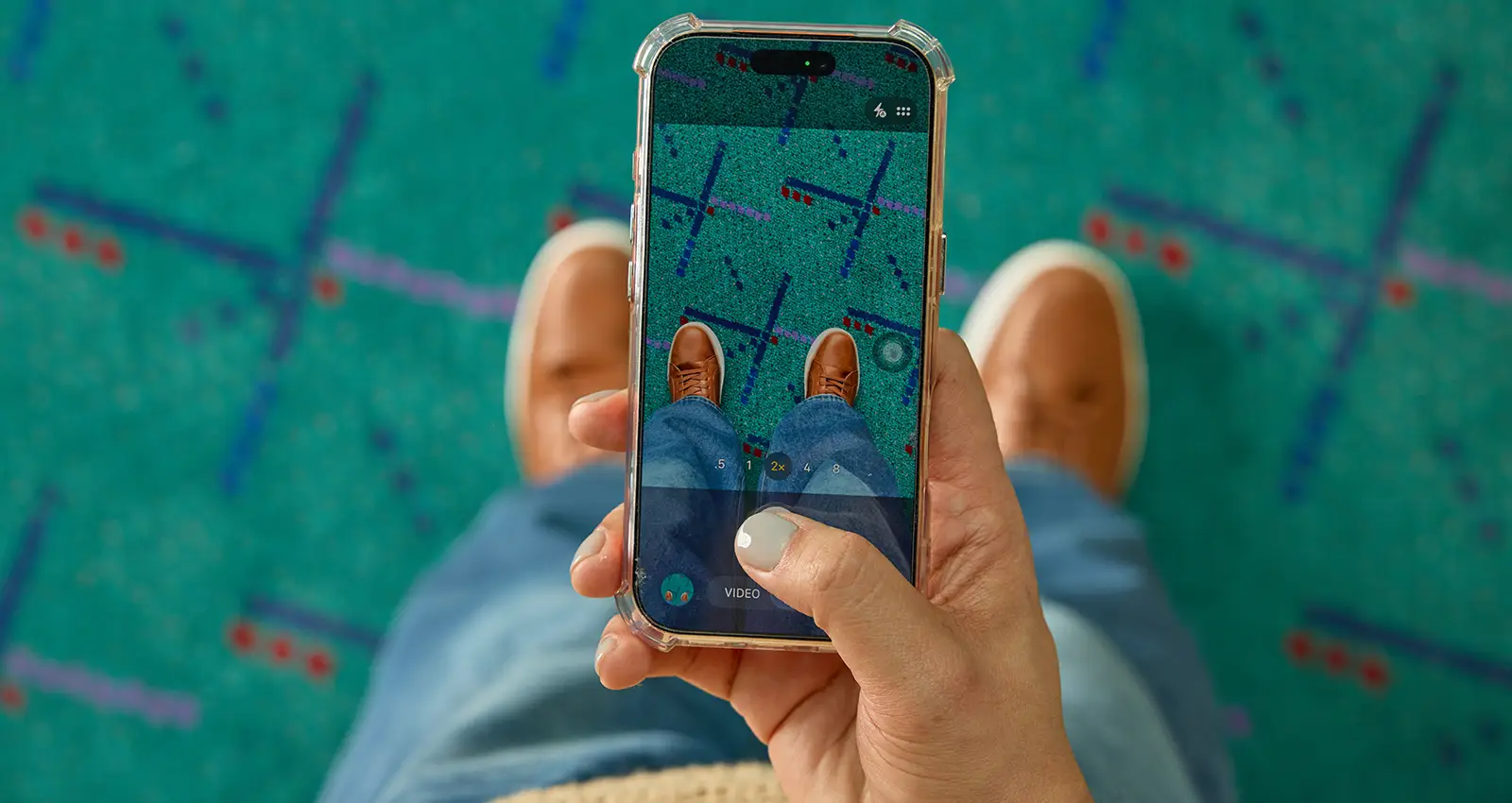 a woman's hand with olive complexion and gray manicure takes a shoe selfie with their smartphone