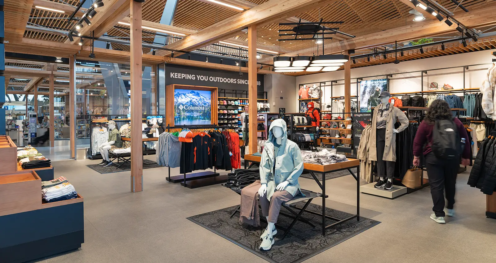 interior shot of Columbia Sportswear with a mannequin wearing denim, sneakers, and a rain jacket in the foreground